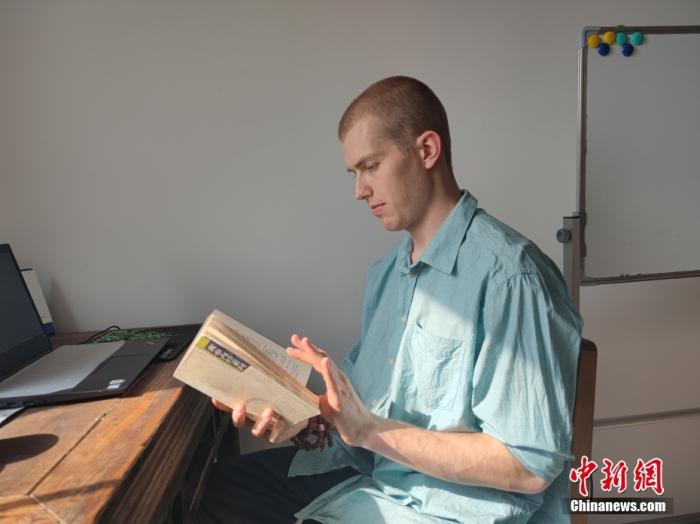 圖為4月20日,，無名在鄭州家中翻閱《黃帝內(nèi)經(jīng)》,。 中新社記者 闞力 攝