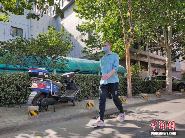 圖為4月20日，無名在所住的小區(qū)散步,。 中新社記者 闞力 攝